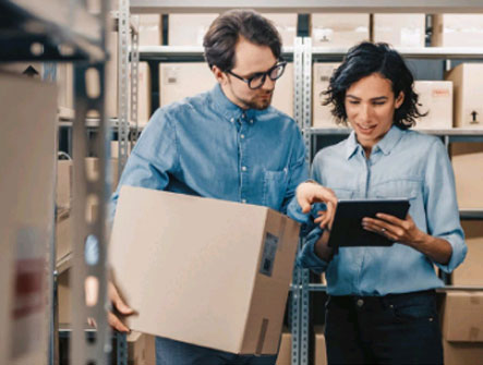 A man and woman discussing work in a warehouse