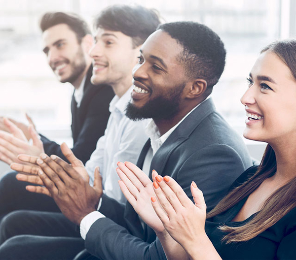 People in a business audience setting, clapping