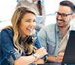 Photo showing a man and woman in from of a computer monitor