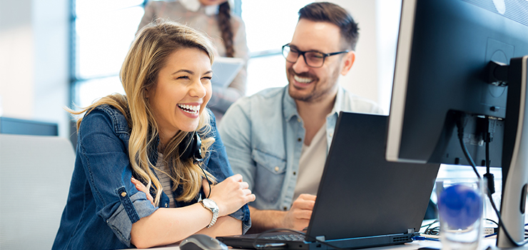 Photo showing a man and woman in from of a computer monitor