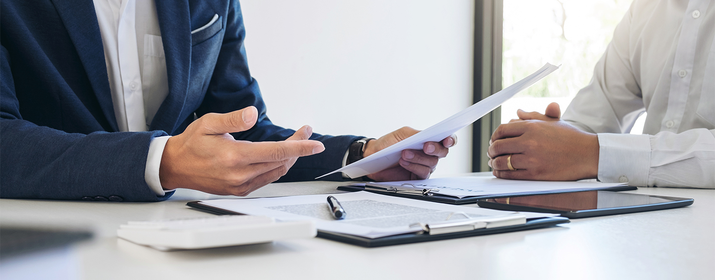 Photo of a person in a business suit reading a printed document