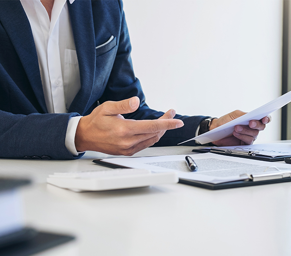 Photo of a person in a business suit reading a printed document